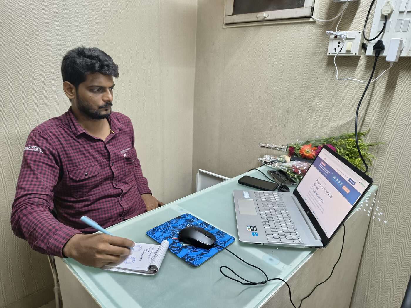 A member of the Sarvoday Solar team talking a customer through a solar proposal at the office