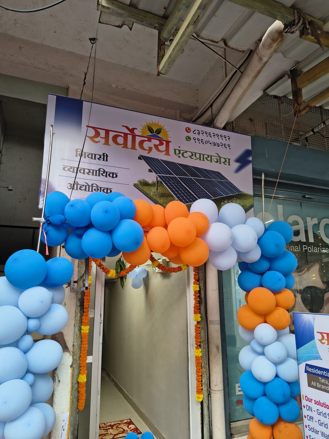 The Sarvoday Solar Solutions shop front in Ratnagiri on its opening day, decorated with balloons and marigold garlands